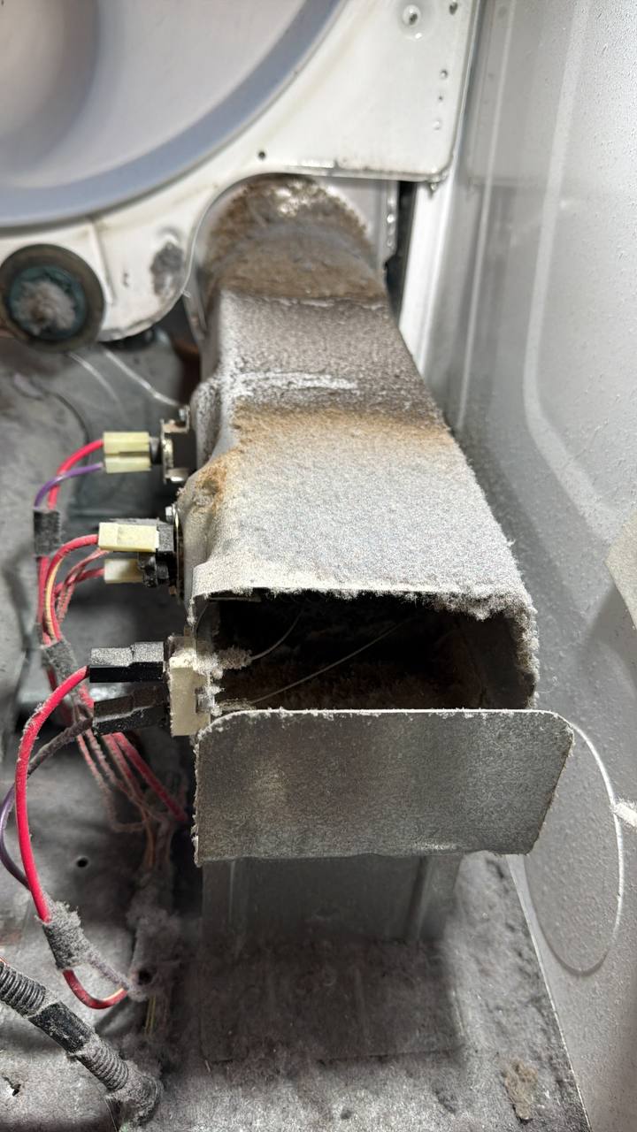 Heavily clogged dryer lint duct requiring professional cleaning and maintenance