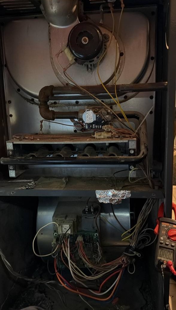 Technician using a multimeter for diagnostic testing during an appliance repair service call